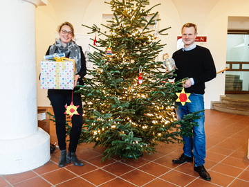 Die Direktorin und der Geschäftsleiter vor dem Tannenbaum