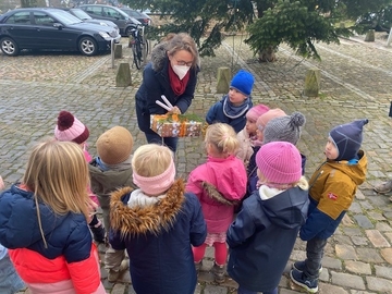 Die Kindergartenkinder übergeben der Direktorin des Amtsgerichts ein Geschenk