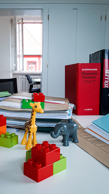 Schreibtisch mit Duplo-Spielzeug und Akten