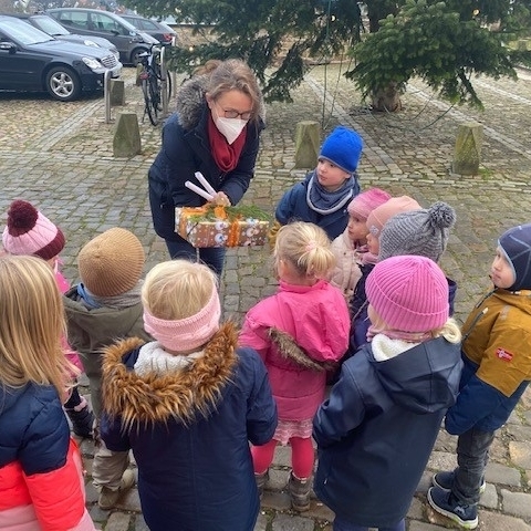 Die Kindergartenkinder übergeben der Direktorin des Amtsgerichts ein Geschenk