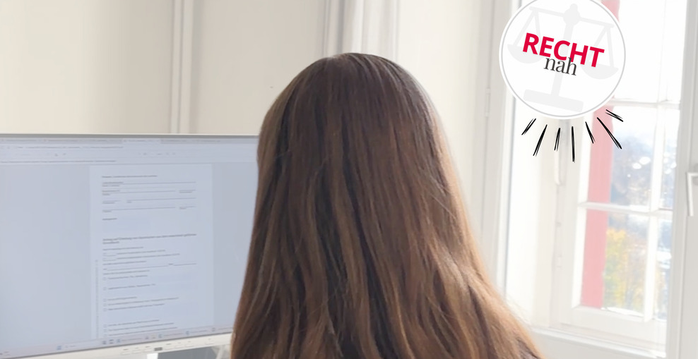 Frau sitzt vor einem Laptopbildschirm